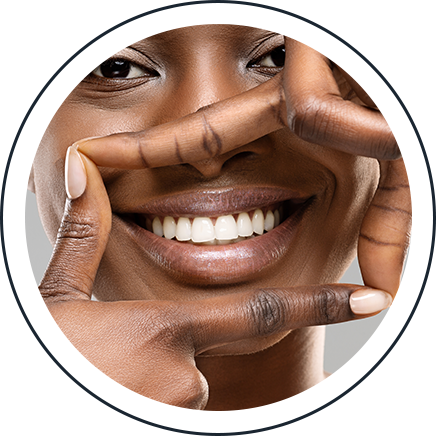Woman framing her bright, white smile with her hands