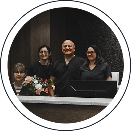 The Deerfoot Dental Centre team standing together at the front reception desk